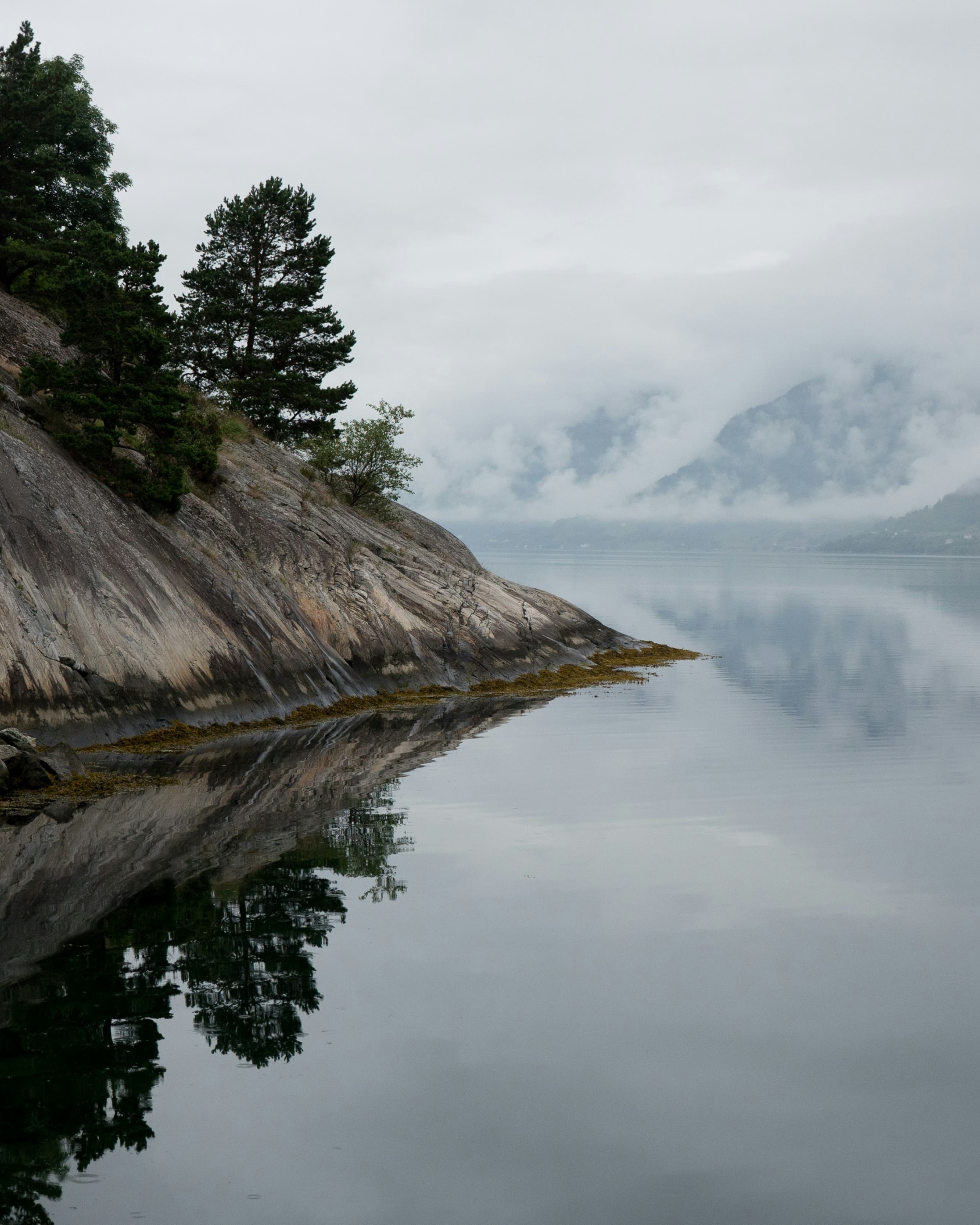 A tranquil Scandinavian landscape with misty mountains and calm waters, reflecting Rbasics' minimalist design philosophy
